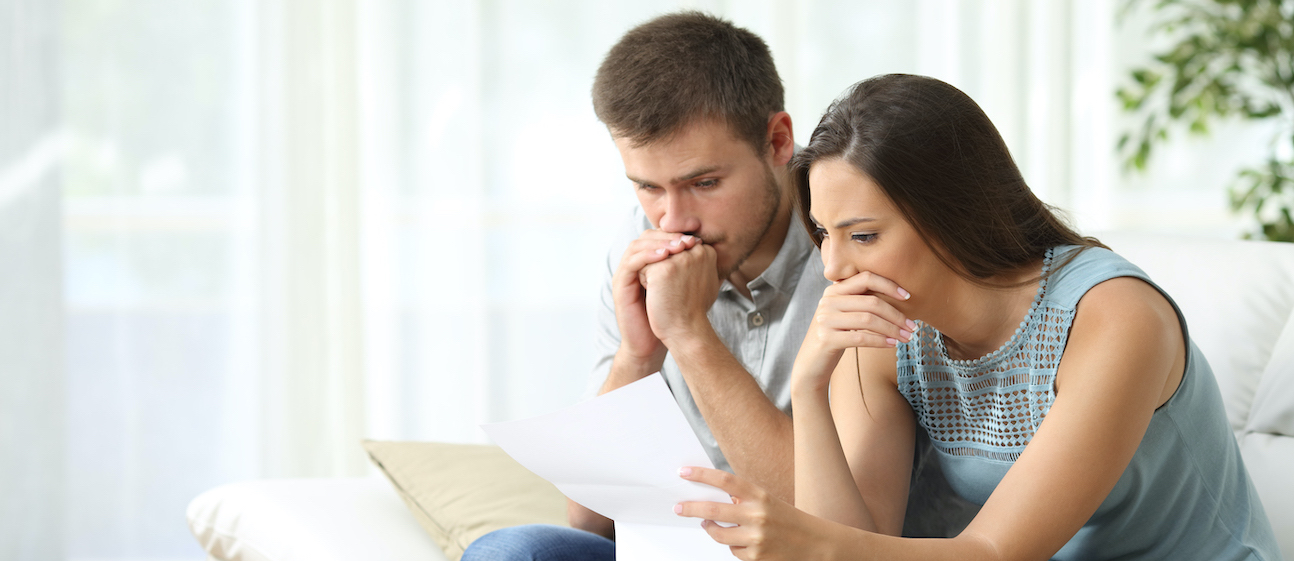 Worried couple reading a letter Couples reviewing a document
